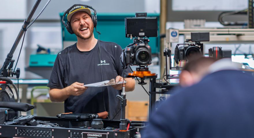 Florian Klaes lacht während eines Videodrehs, umringt von seinem Videoequipment